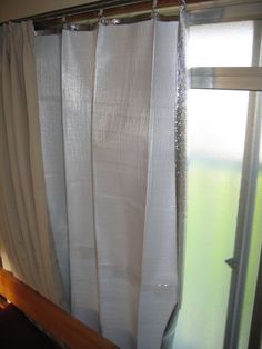 an open window with white sheer curtains on it