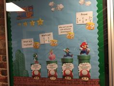 a bulletin board with mario's train and other things on it in front of a brick wall