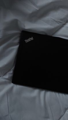 an open laptop computer sitting on top of a white sheet