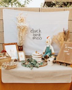 a table topped with a cake and stuffed animals on top of it next to pictures