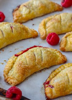 raspberries and pastries on a baking sheet