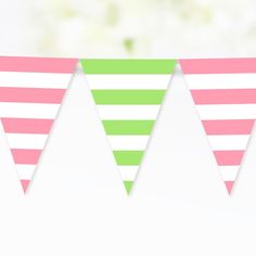 three pink, green and white striped buntings on a string with flowers in the background