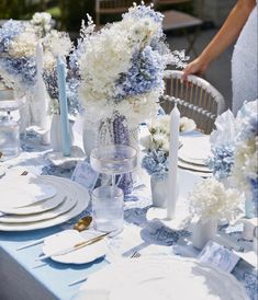 the table is set with blue and white flowers