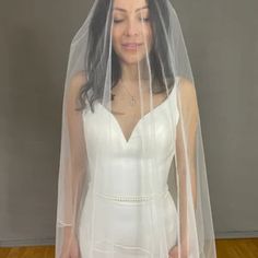 a woman wearing a white wedding dress and veil