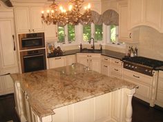 a kitchen with marble counter tops and an island in front of a stove top oven