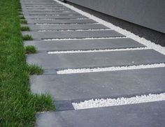 the sidewalk is lined with stones and grass