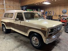 a truck parked in a garage next to a wall with wood paneling on it