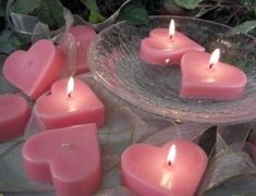 many pink candles are placed in a bowl