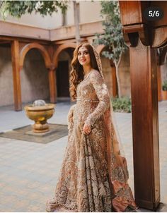 a woman in a bridal gown standing by a fountain