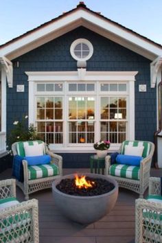 a fire pit sitting on top of a wooden floor next to two chairs and a table