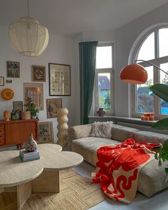 a living room filled with lots of furniture and large round windows above the couches