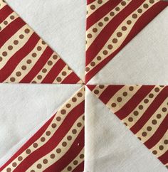 a red and white piece of fabric with brown dots on it that has been cut into triangles