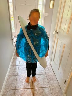 a person holding a surfboard in their hands and covering them with a blue tarp