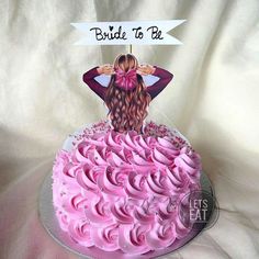 a birthday cake with pink frosting and a cutout of a woman on top