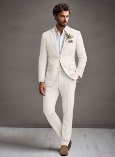 a man in a white suit and brown shoes