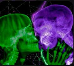 two purple and green skulls are facing each other