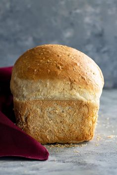 a loaf of bread sitting on top of a table next to a red cloth and knife