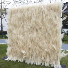 a large furry rug sitting on top of a lush green field