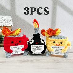 three crocheted stuffed animals sitting next to each other on top of a table