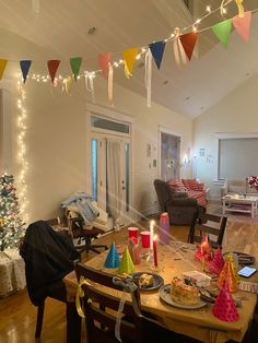 a dining room table is decorated with birthday hats and candles for the holiday season,