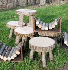 several pieces of wood stacked on top of each other in the grass near some logs