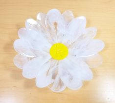 a plastic flower sitting on top of a wooden table