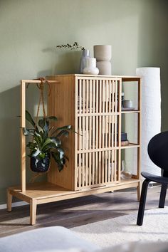 a wooden cabinet with plants on it in a room