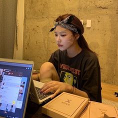 a woman sitting on the floor using a laptop computer