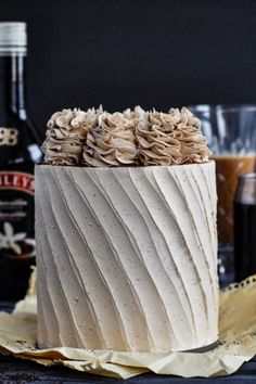 a white cake with frosting and ruffles sitting on top of a table