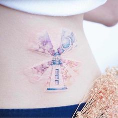 a woman's stomach with an artistic tattoo on it