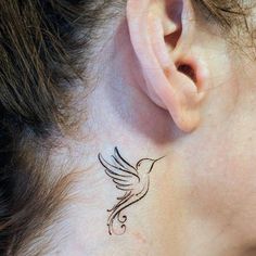 a woman's behind the ear with a bird tattoo on her left side neck