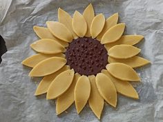 a sunflower shaped cookie sitting on top of a piece of wax paper