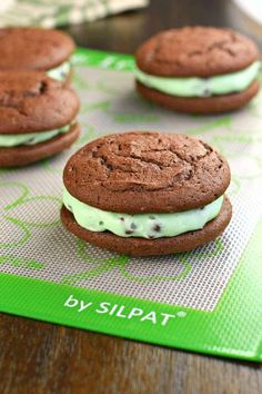 chocolate cookies with green frosting and oreo cookies on a cookie sheet, ready to be eaten