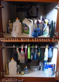 an organized kitchen cabinet filled with cleaning products