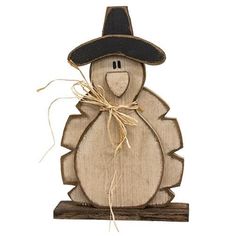 a wooden cutout of a turkey wearing a black hat and holding a string in it's mouth