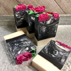 four soap bars decorated with pink and green flowers on top of a marble countertop