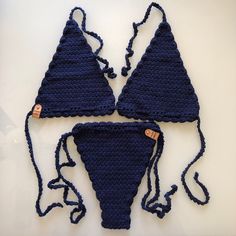 three pieces of crocheted bikinis are shown on a white surface, one is blue and the other is brown