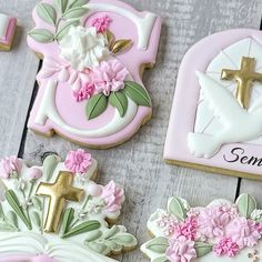 decorated cookies with flowers and cross on them sitting on a wooden table next to the word jesus