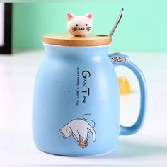 a blue coffee mug with a cat on top and a toothbrush in the cup