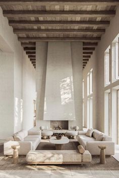 a large living room with high ceilings and wooden beams on the ceiling is filled with furniture