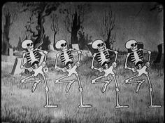 three skeletons are dancing in the grass