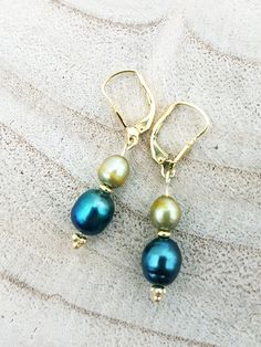 Earrings made of 14 carat gold plated Sterling silver with light olive green and blue freshwater pearls. Total length including ear hook:  3.5 cm Green Pearl Charm Drop Earrings, Blue Drop Pearl Earrings With Pearl Charm, Green Dangle Pearl Earrings With Ear Wire, Green Pearl Drop Earrings, Olive Green And Blue, Light Olive Green, Freshwater Pearl Earrings, Earring Designs, Freshwater Pearls Earrings