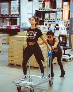 a man and woman pushing a dolly in a warehouse