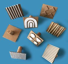 several different shapes and sizes of cardboard boxes on a blue background with some paper cutouts