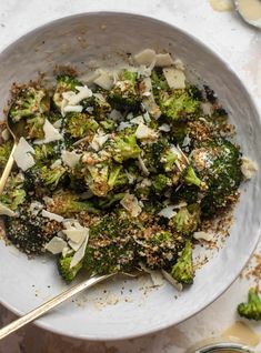 a white bowl filled with broccoli covered in seasoning and sprinkles