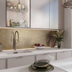 a kitchen with white counter tops and gold backsplashing on the wall above the sink