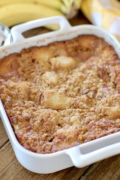 a close up of a casserole on a table with bananas in the background