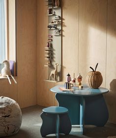 a blue table and two stools in a room