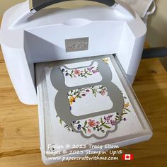 a white printer sitting on top of a wooden table