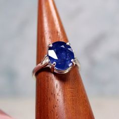 a blue ring sitting on top of a wooden table next to a piece of wood